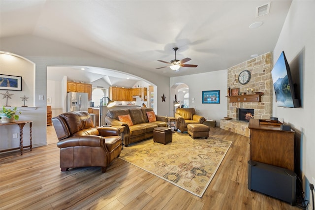 1608 Fallingwater Trl, Fort Worth, TX 76052 - living area featuring arched walkways, ceiling fan, lofted ceiling, light wood finished floors, and a fireplace