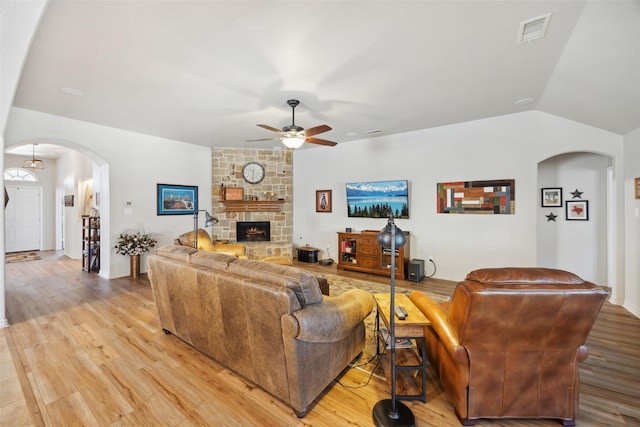 1608 Fallingwater Trl, Fort Worth, TX 76052 - living area featuring arched walkways, a ceiling fan, light wood-style floors, lofted ceiling, and a stone fireplace