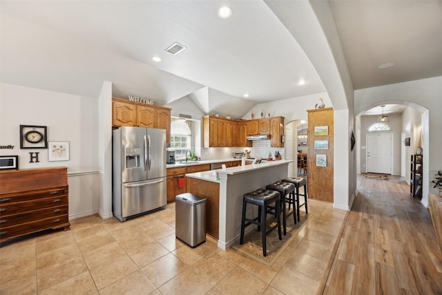 1608 Fallingwater Trl, Fort Worth, TX 76052 - kitchen featuring stainless steel appliances, arched walkways, a sink, lofted ceiling, and light countertops