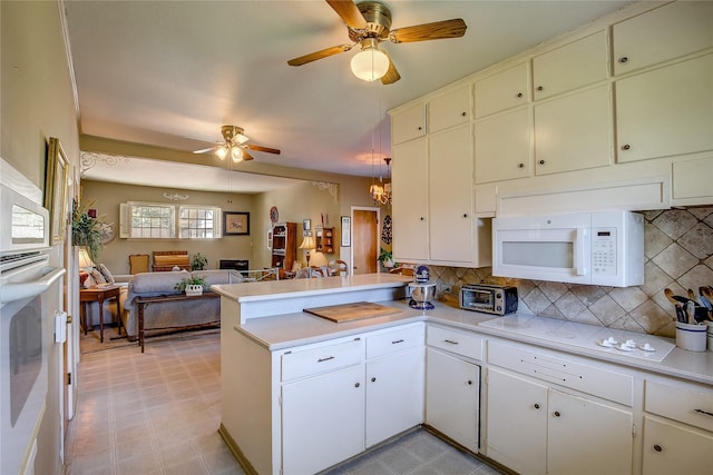 1005 Church St, Sulphur Springs, TX 75482 - kitchen with white appliances, a peninsula, a ceiling fan, open floor plan, and light countertops