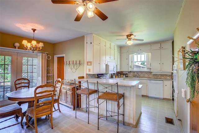 1005 Church St, Sulphur Springs, TX 75482 - kitchen featuring white appliances, a ceiling fan, light flooring, decorative backsplash, and a peninsula
