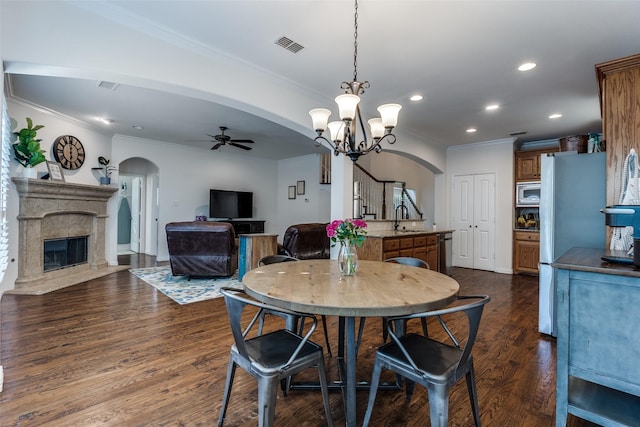 dining area with arched walkways, ceiling fan, recessed lighting, a high end fireplace, and crown molding