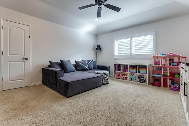 carpeted living area with ceiling fan and vaulted ceiling