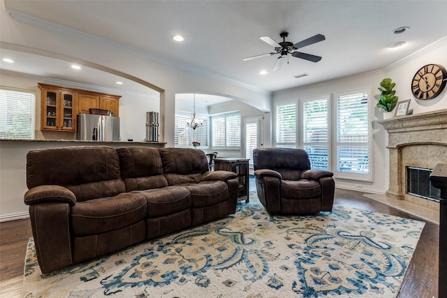 living room featuring wood finished floors, arched walkways, ornamental molding, ceiling fan, and recessed lighting