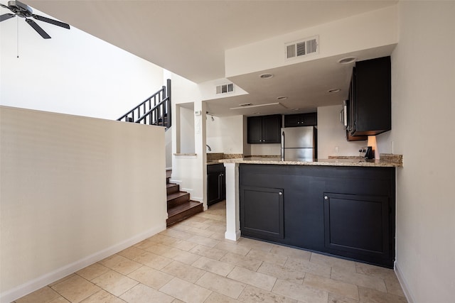 6808 Eastridge Dr Unit A7, Dallas, TX 75231 - kitchen featuring stainless steel appliances, a ceiling fan, baseboards, a peninsula, and light stone countertops