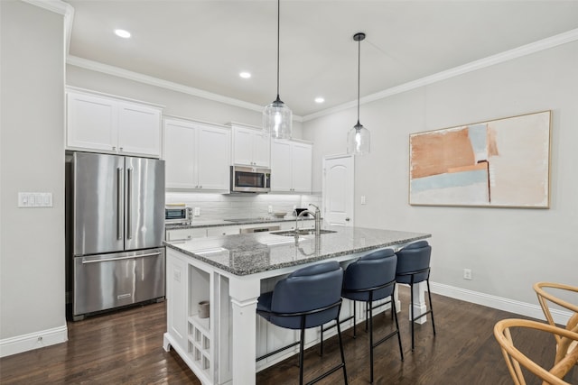719 Hammond St, Coppell, TX 75019 - kitchen with stainless steel appliances, light stone countertops, backsplash, white cabinetry, and an island with sink