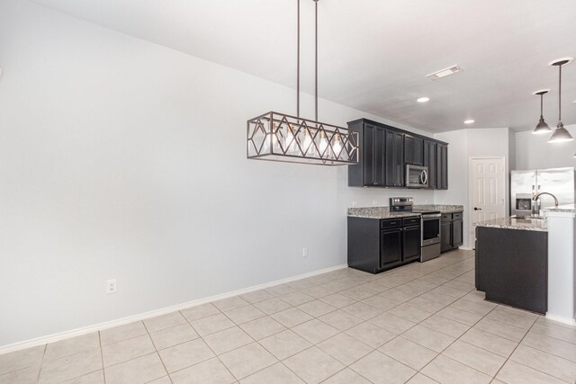 kitchen featuring appliances with stainless steel finishes, dark cabinets, a sink, light tile patterned flooring, and recessed lighting