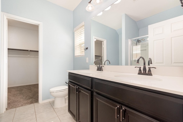 full bath with a shower stall, a spacious closet, tile patterned floors, double vanity, and toilet
