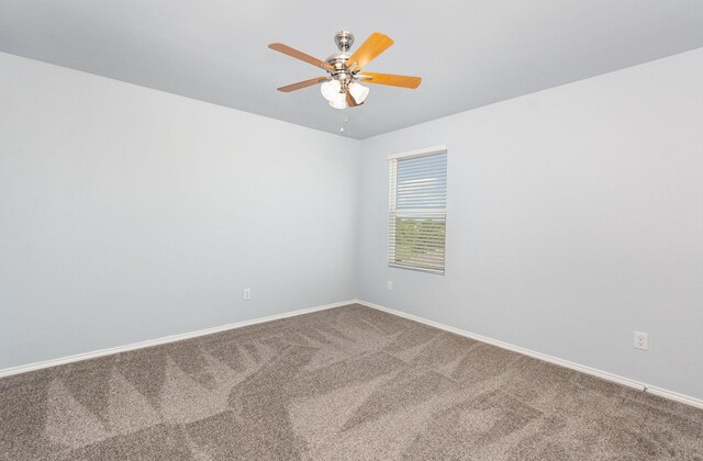 carpeted empty room with ceiling fan and baseboards