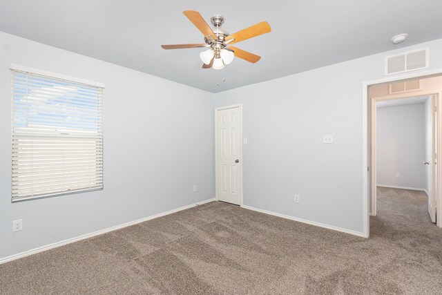 spare room featuring carpet flooring, ceiling fan, and baseboards