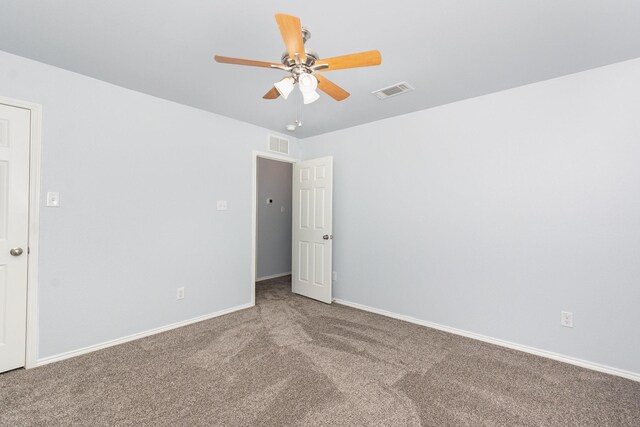 carpeted empty room with ceiling fan and baseboards