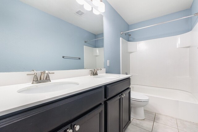 bathroom featuring washtub / shower combination, toilet, double vanity, and tile patterned floors