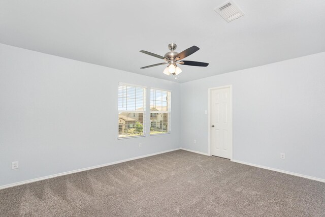 carpeted spare room with ceiling fan and baseboards