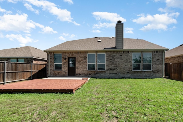 rear view of house featuring a chimney, a deck, and brick siding