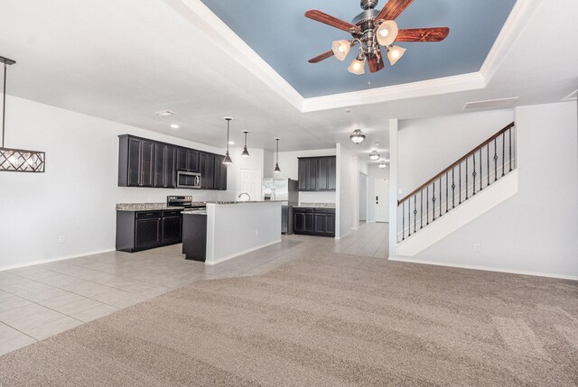 kitchen featuring appliances with stainless steel finishes, open floor plan, light tile patterned floors, a raised ceiling, and ceiling fan