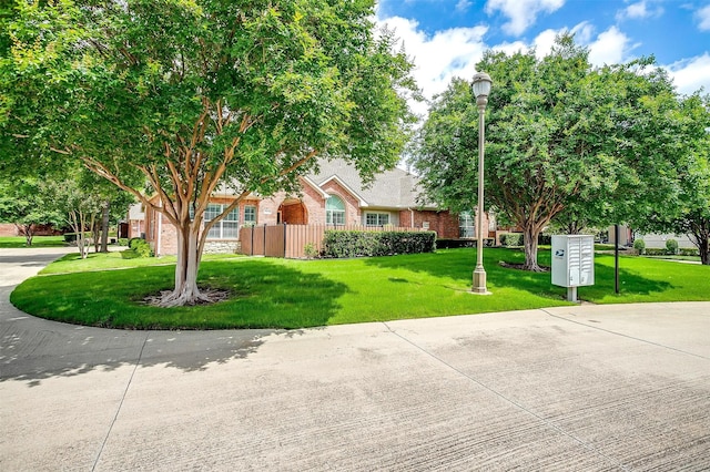 view of property hidden behind natural elements with brick siding