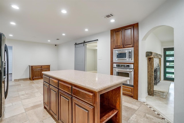 7000 County Road 527, Burleson, TX 76028 - kitchen featuring appliances with stainless steel finishes, a barn door, recessed lighting, a kitchen island, and arched walkways