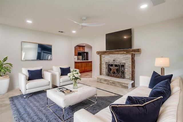 7000 County Road 527, Burleson, TX 76028 - living room with arched walkways, light tile patterned floors, a ceiling fan, a fireplace with raised hearth, and recessed lighting