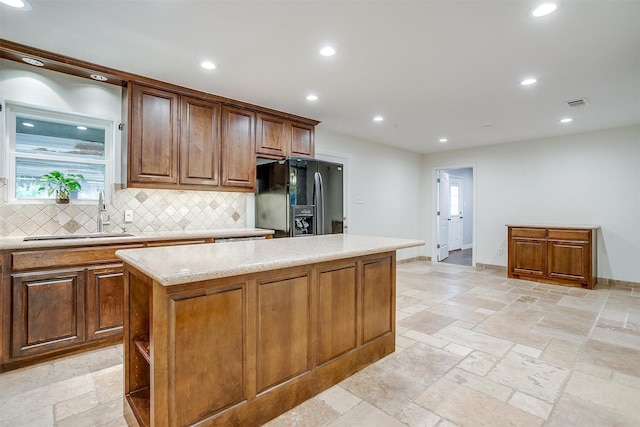 7000 County Road 527, Burleson, TX 76028 - kitchen with black fridge, a sink, decorative backsplash, healthy amount of natural light, and recessed lighting