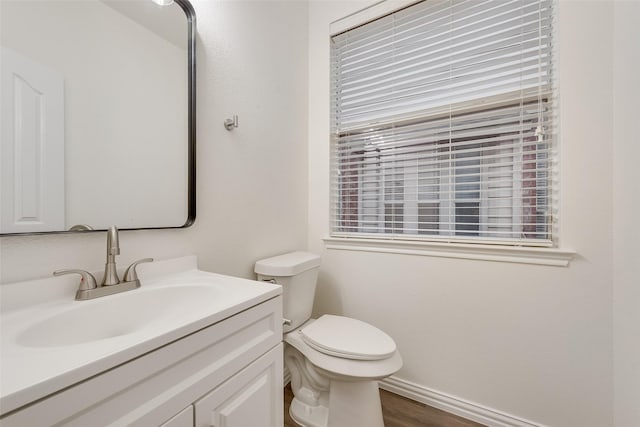 10832 Hawks Landing Rd, Fort Worth, TX 76052 - half bathroom featuring toilet, vanity, baseboards, wood finished floors, and healthy amount of natural light