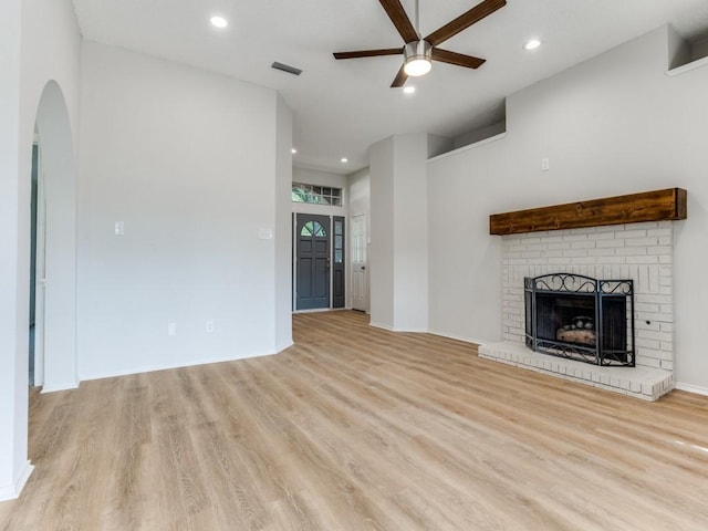unfurnished living room with ceiling fan, light wood-type flooring, a brick fireplace, recessed lighting, and baseboards