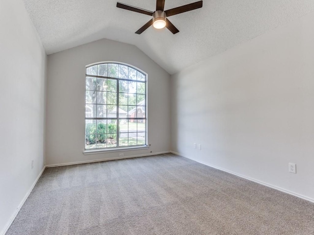 unfurnished room featuring a ceiling fan, carpet, vaulted ceiling, a textured ceiling, and baseboards
