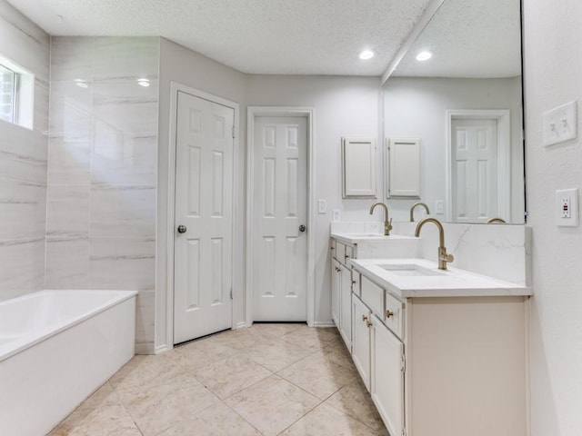 bathroom with vanity, a textured ceiling, recessed lighting, and tile patterned flooring