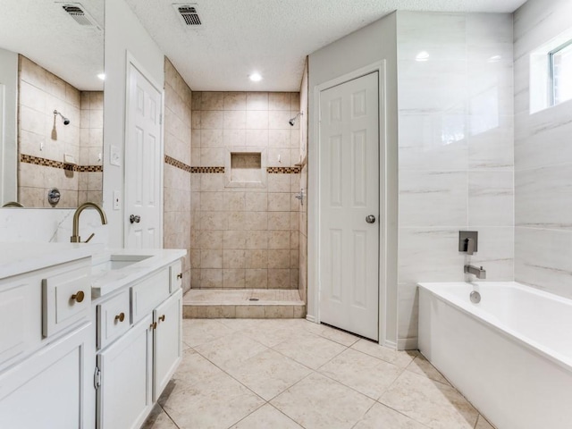 full bath featuring a tile shower, vanity, tile patterned floors, a bath, and a textured ceiling