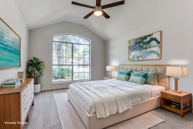 bedroom featuring light colored carpet, lofted ceiling, a textured ceiling, and a ceiling fan