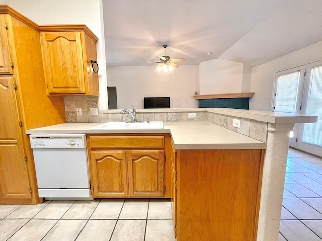 kitchen with white dishwasher, a sink, light tile patterned flooring, a ceiling fan, and a peninsula