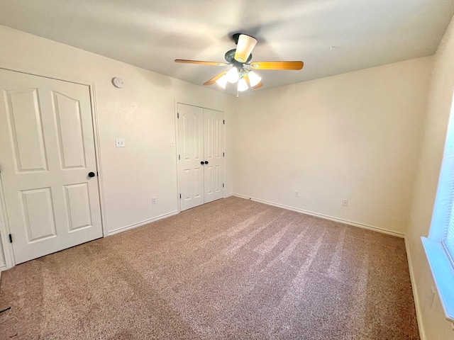 unfurnished bedroom with carpet flooring, baseboards, ceiling fan, and a closet