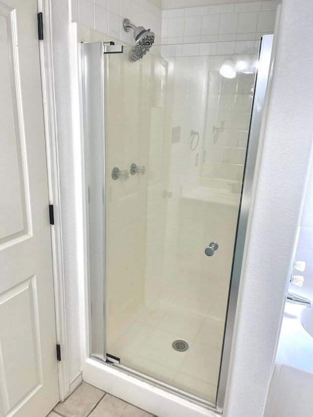 full bath with a stall shower and tile patterned flooring