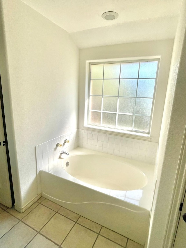 bathroom with plenty of natural light, tile patterned floors, and a bath