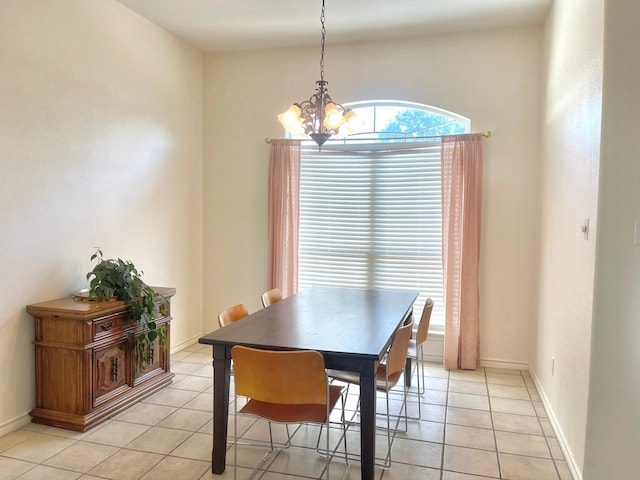 dining room with a chandelier, light tile patterned floors, and baseboards