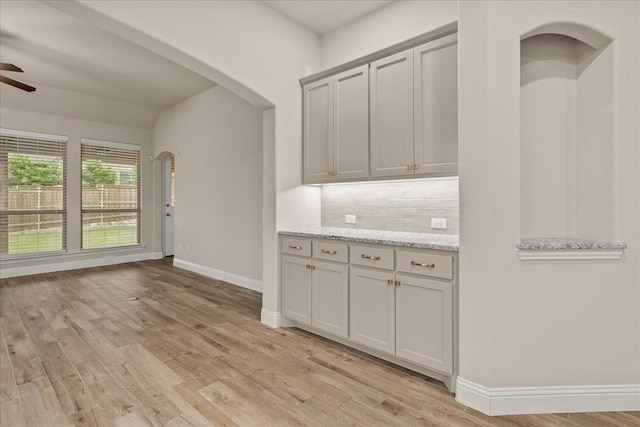 8325 Western, The Colony, TX 75056 - kitchen featuring a ceiling fan, tasteful backsplash, light wood-type flooring, baseboards, and arched walkways