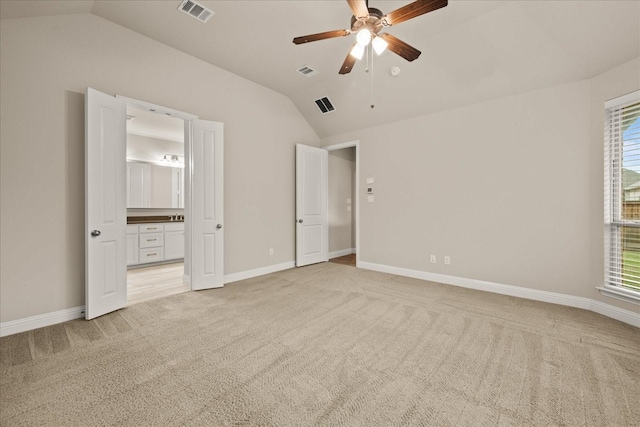 8325 Western, The Colony, TX 75056 - unfurnished bedroom featuring vaulted ceiling, light carpet, baseboards, connected bathroom, and a ceiling fan
