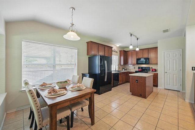 6008 Creekway Dr, Denton, TX 76226 - kitchen featuring black appliances, light tile patterned floors, light countertops, a kitchen island, and decorative light fixtures