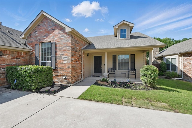 6008 Creekway Dr, Denton, TX 76226 - view of front of house with covered porch, a front yard, and brick siding