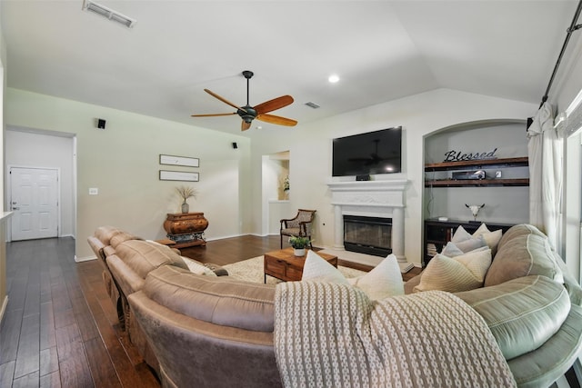 6008 Creekway Dr, Denton, TX 76226 - living area with a glass covered fireplace, a ceiling fan, dark wood-style flooring, lofted ceiling, and built in shelves