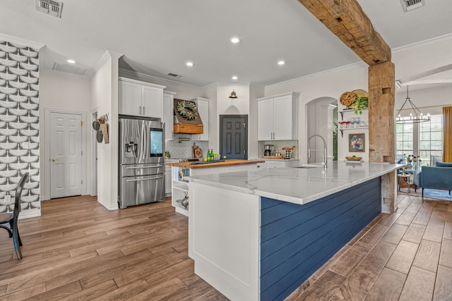 147 Rim Rock Rd, Aledo, TX 76008 - kitchen with stainless steel fridge, light wood finished floors, a sink, crown molding, and white cabinets
