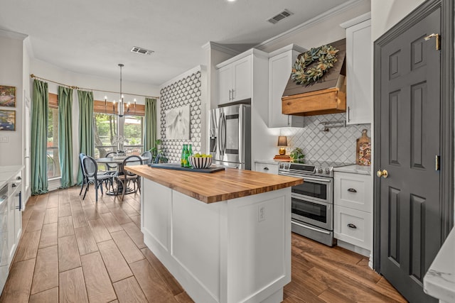 147 Rim Rock Rd, Aledo, TX 76008 - kitchen with wooden counters, stainless steel appliances, ornamental molding, a chandelier, and white cabinetry