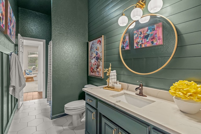 147 Rim Rock Rd, Aledo, TX 76008 - bathroom featuring tile patterned floors, toilet, vanity, and wood walls