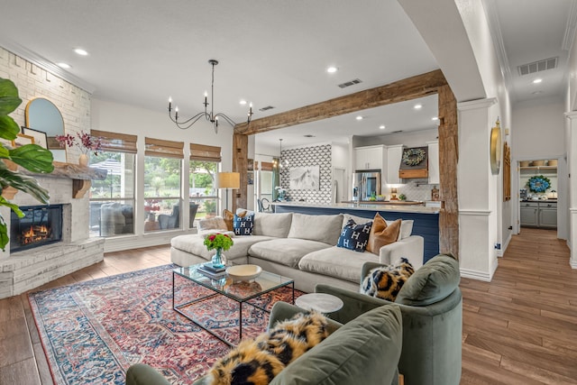 147 Rim Rock Rd, Aledo, TX 76008 - living room with a chandelier, light wood-style floors, a brick fireplace, recessed lighting, and crown molding