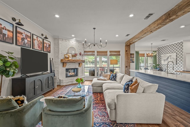 147 Rim Rock Rd, Aledo, TX 76008 - living room featuring a chandelier, wood finished floors, ornamental molding, recessed lighting, and a fireplace