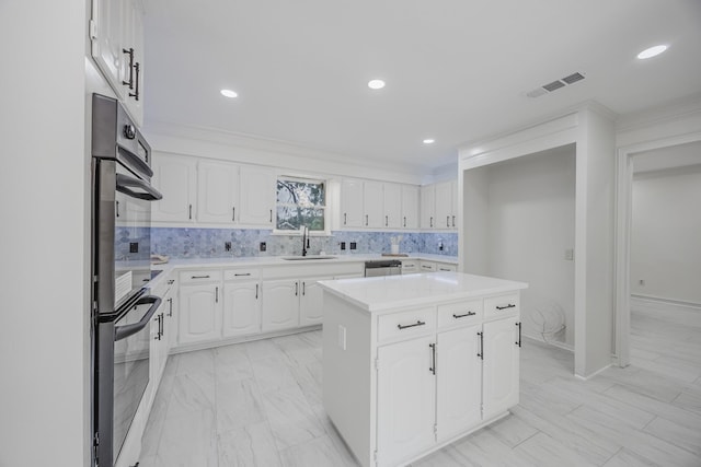 62 Legend Rd, Benbrook, TX 76132 - kitchen featuring a sink, stainless steel appliances, light countertops, a kitchen island, and white cabinetry