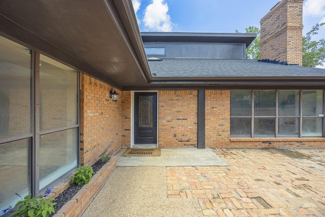 62 Legend Rd, Benbrook, TX 76132 - property entrance with brick siding, a shingled roof, a chimney, and a patio area