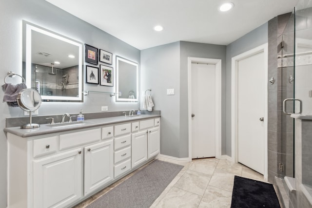 full bathroom featuring a shower stall, double vanity, recessed lighting, and baseboards