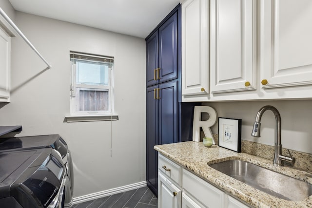 laundry room featuring cabinet space, washing machine and clothes dryer, and baseboards