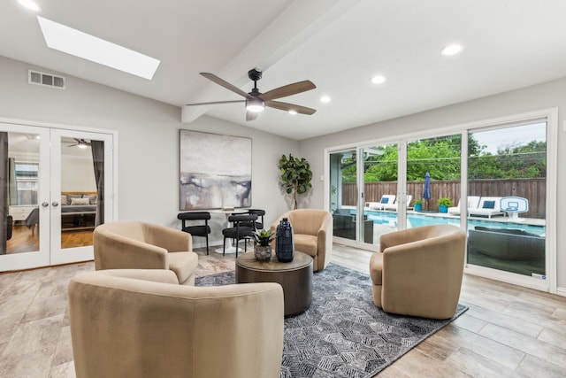 living room with vaulted ceiling, a ceiling fan, french doors, recessed lighting, and a skylight