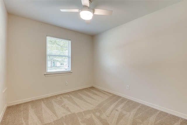 empty room with light colored carpet, baseboards, and ceiling fan